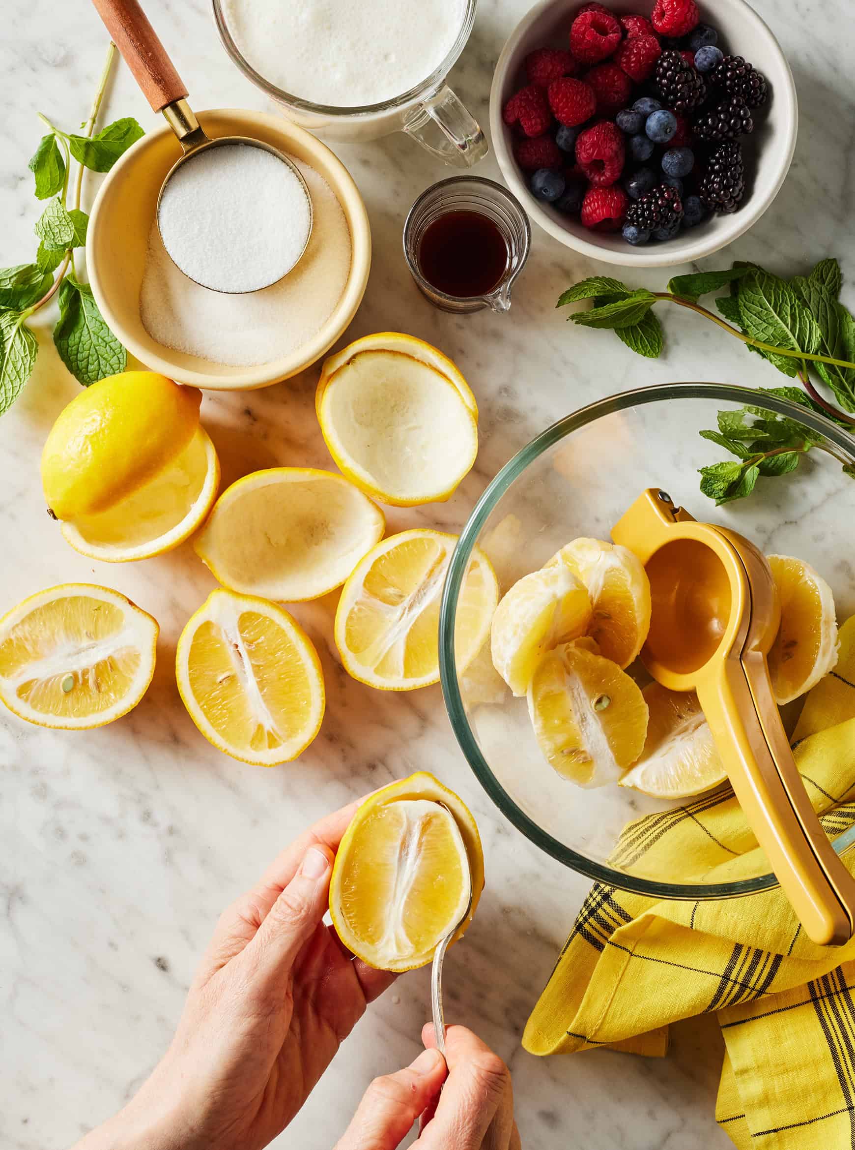 Scooping insides out of lemon halves with spoon