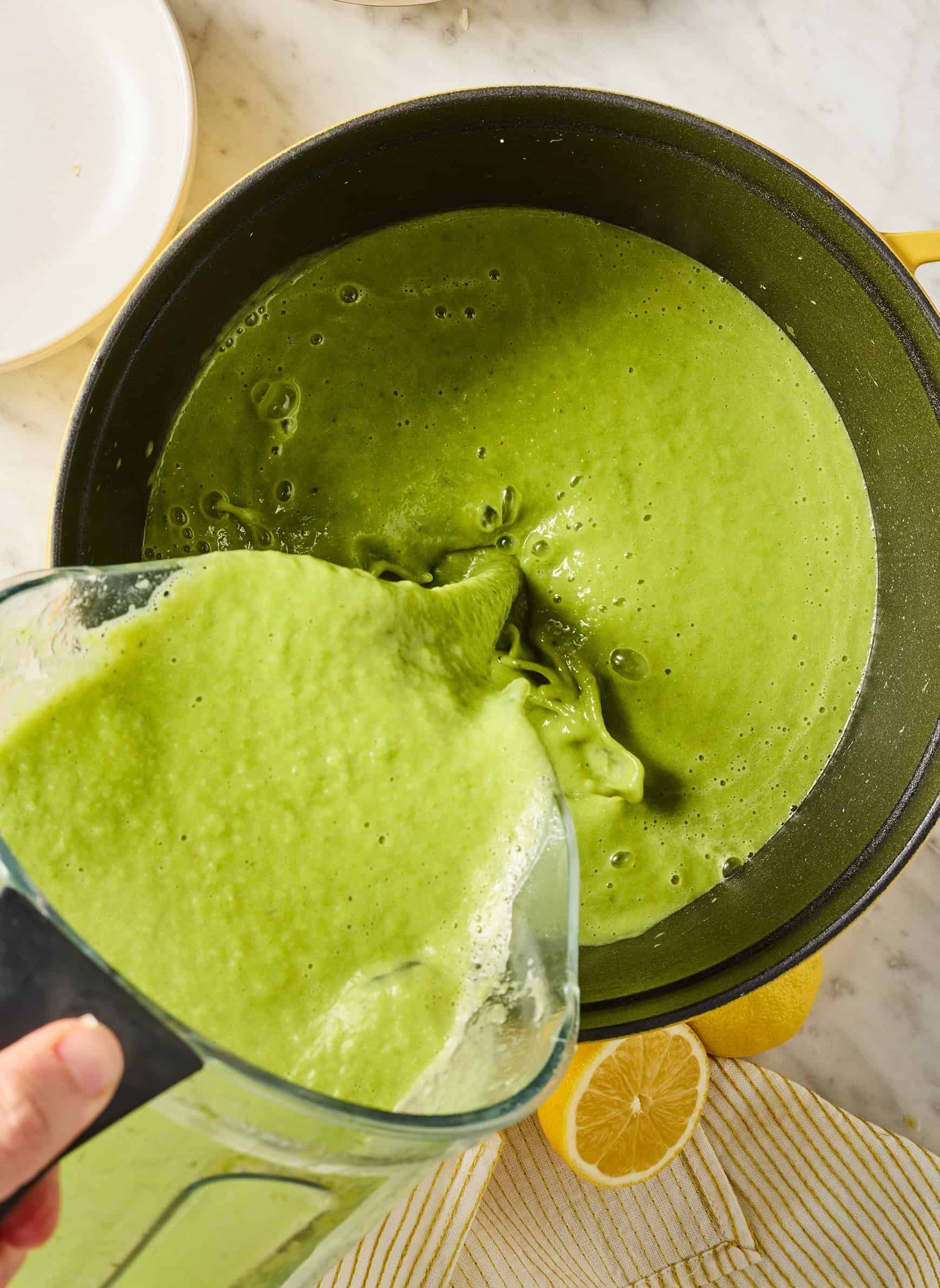Pouring bright green puree into pot