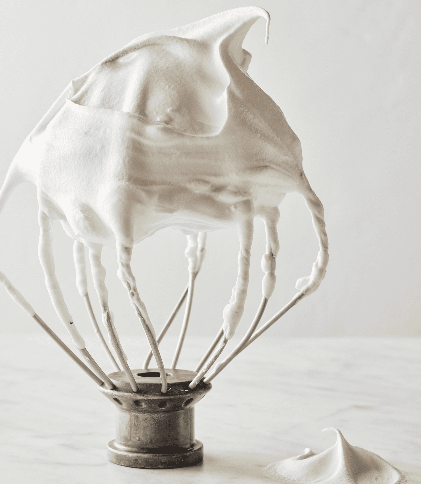 Whipped cream with medium peaks on the whisk attachment.