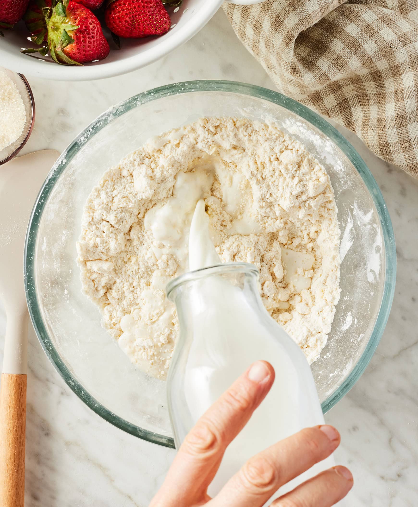 Pouring milk into bowl with flour mixture