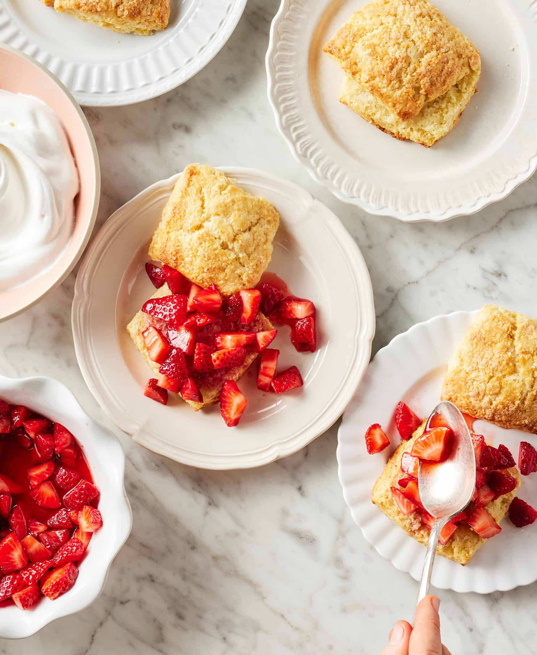 Spooning strawberries onto homemade biscuits