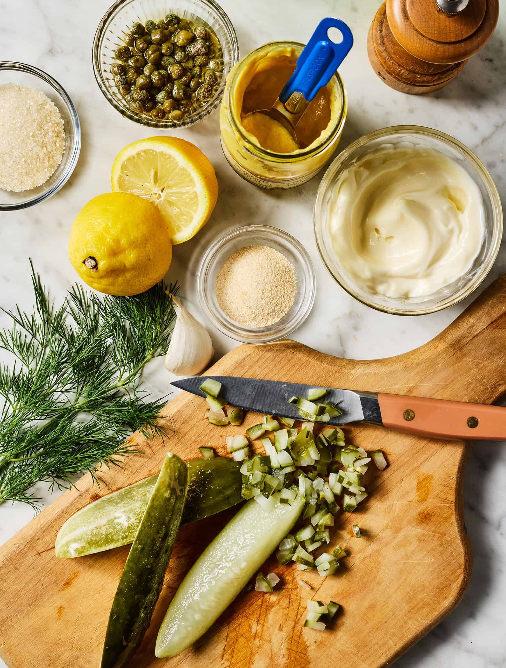 Tartar sauce recipe ingredients on marble counter