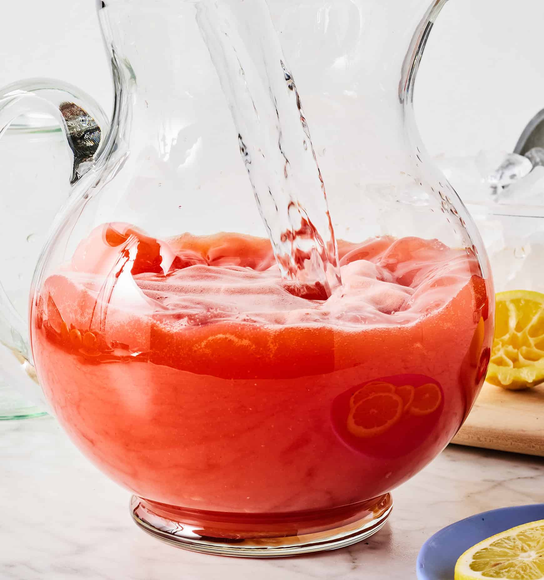 Pouring water into pitcher with strawberry puree