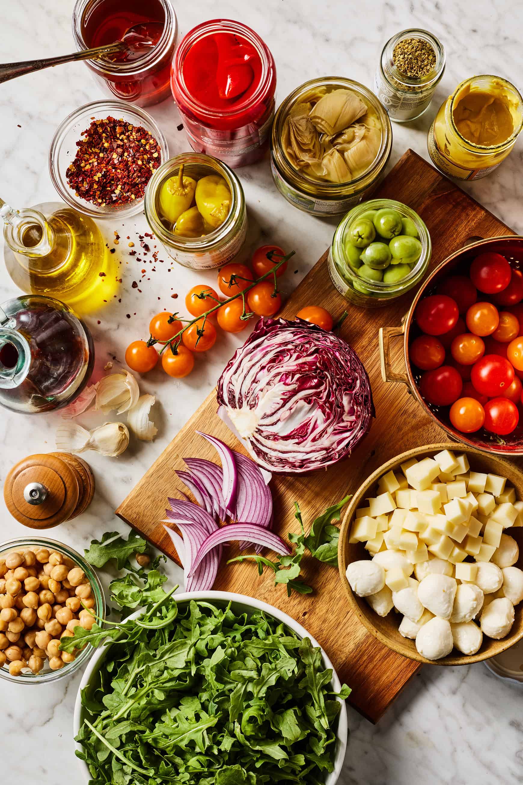 Antipasto salad recipe ingredients on marble countertop