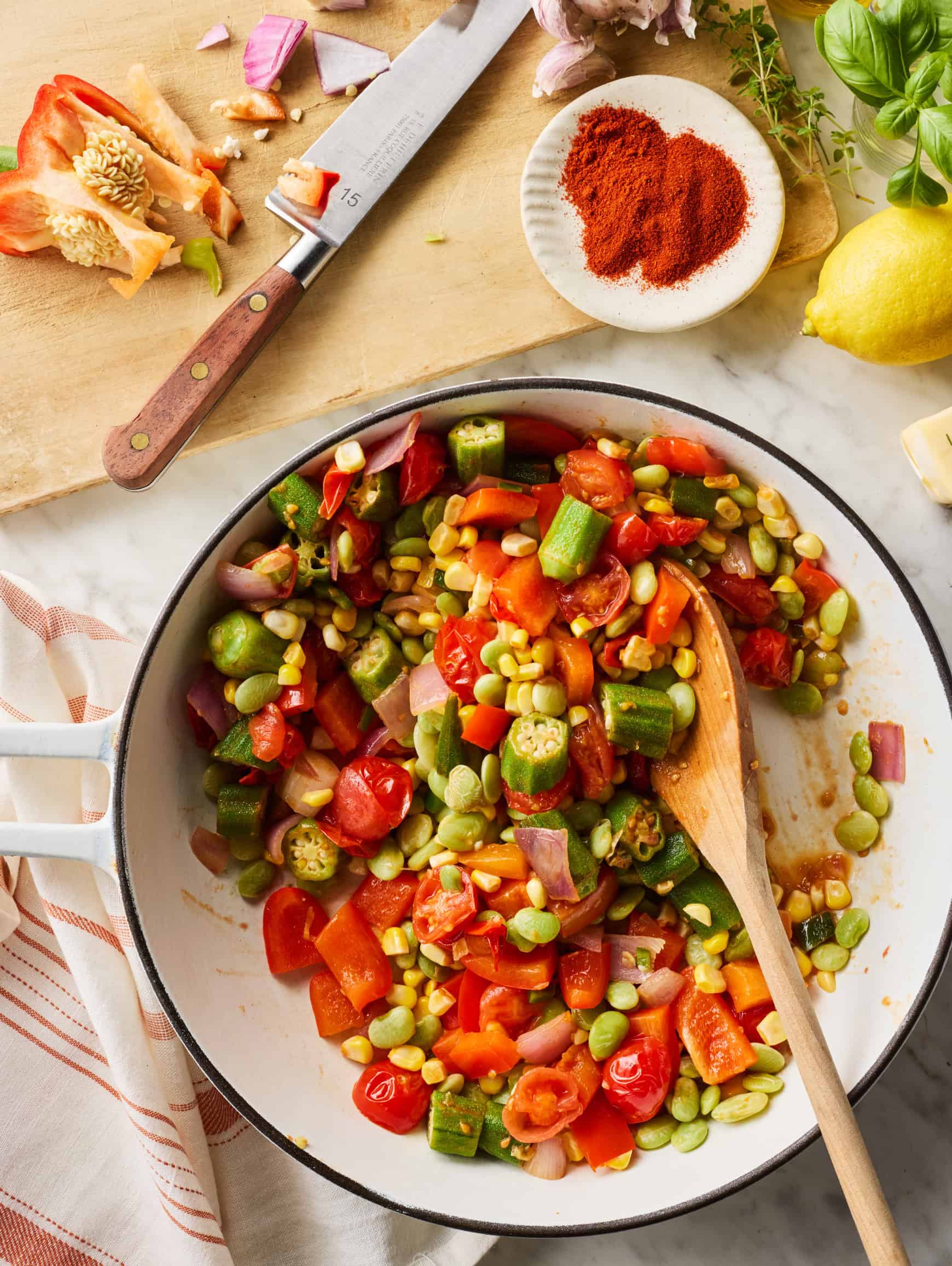 Mixing succotash in skillet with wooden spoon