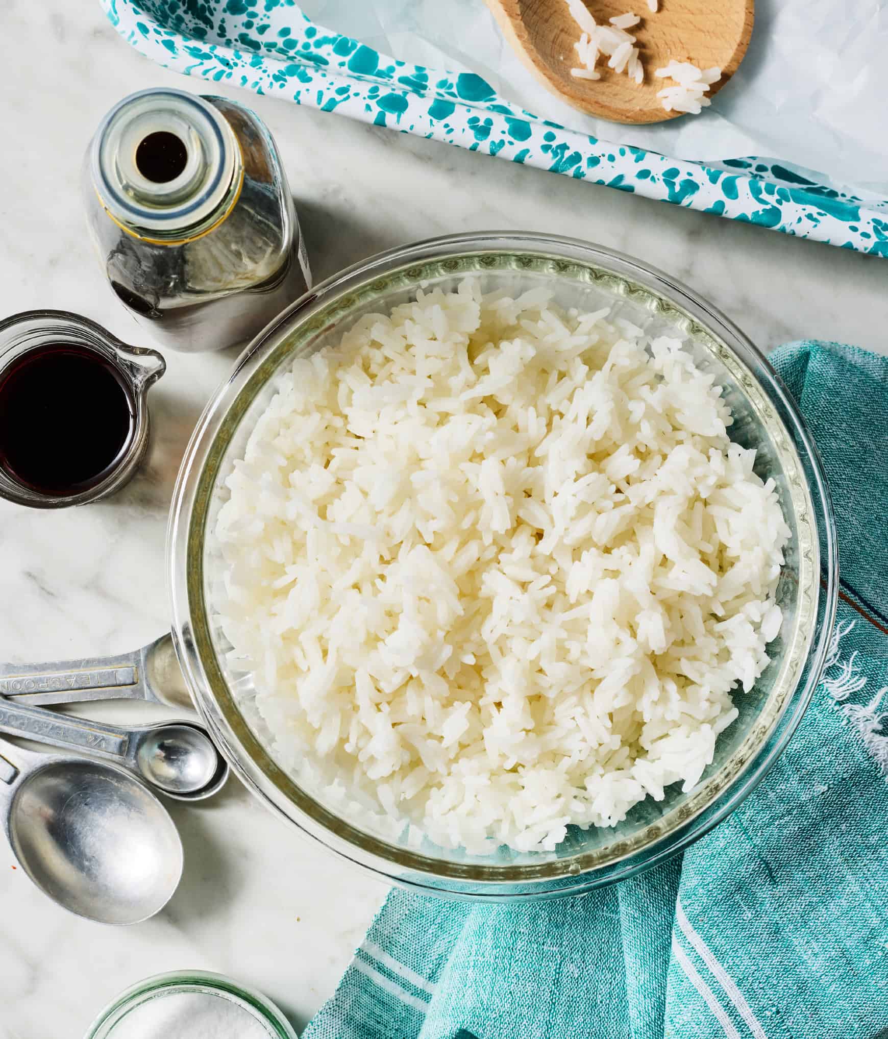 Cooked white rice, soy sauce, and sesame oil on countertop