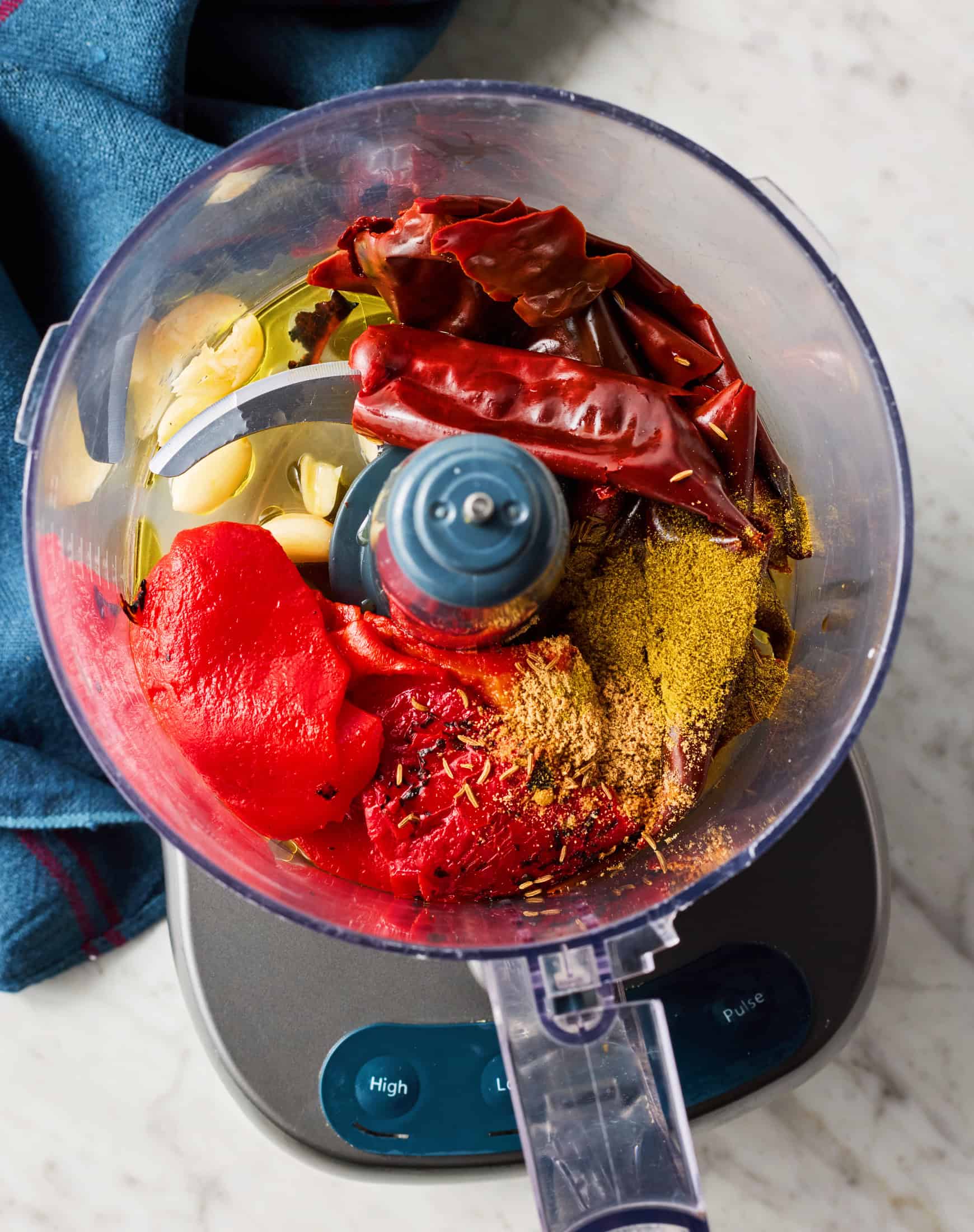 Dried chiles, roasted peppers, spices, garlic, and oil in food processor