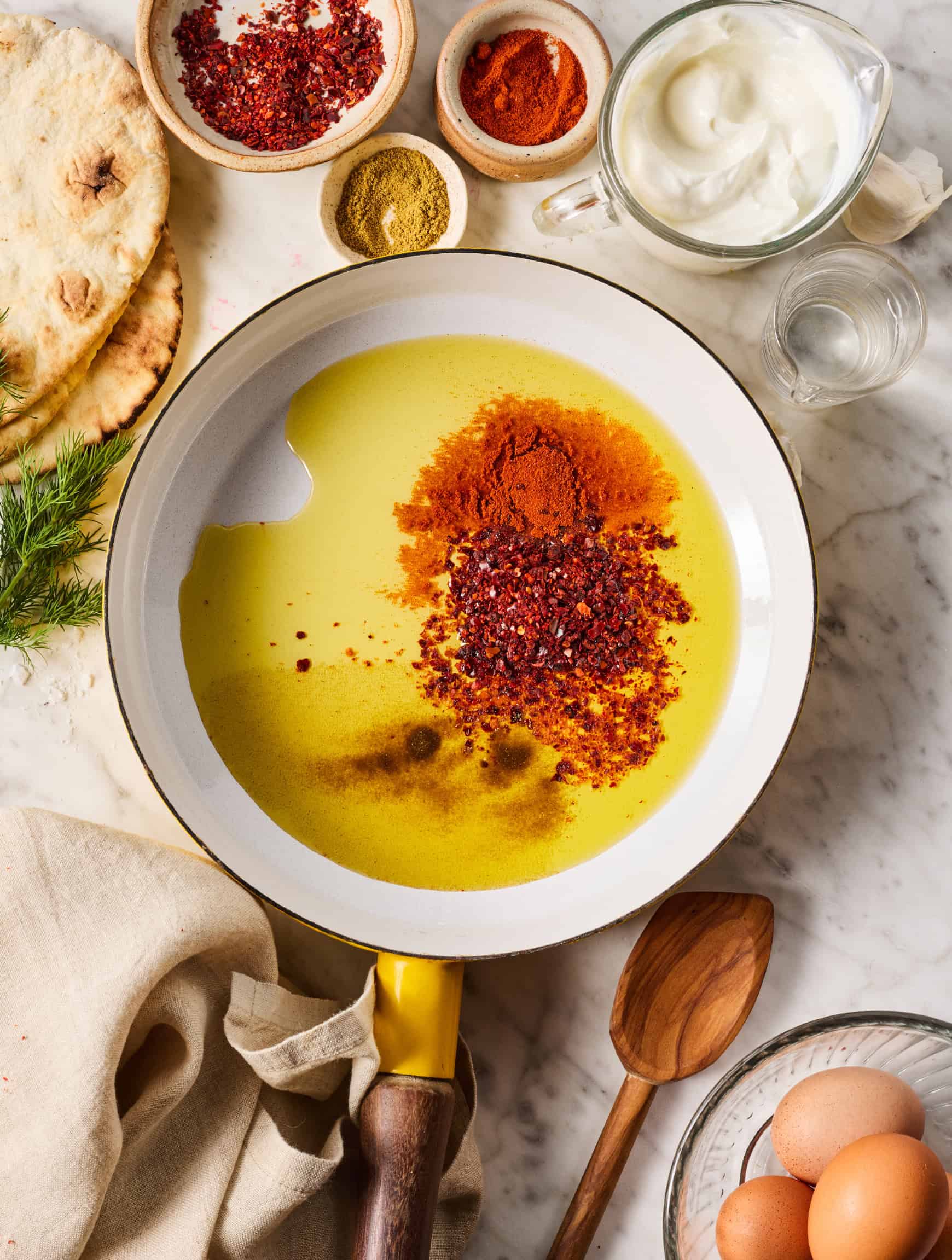 Aleppo pepper, cumin, and paprika in pool of olive oil in small skillet