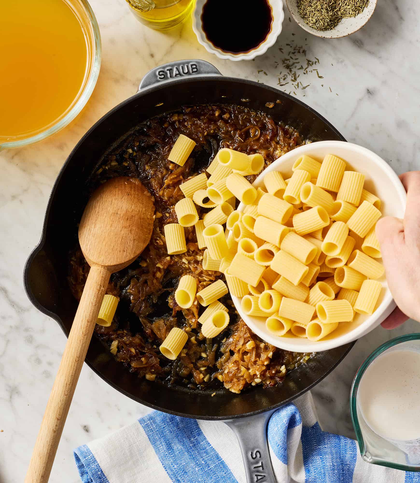 Adding rigatoni to skillet with caramelized onions