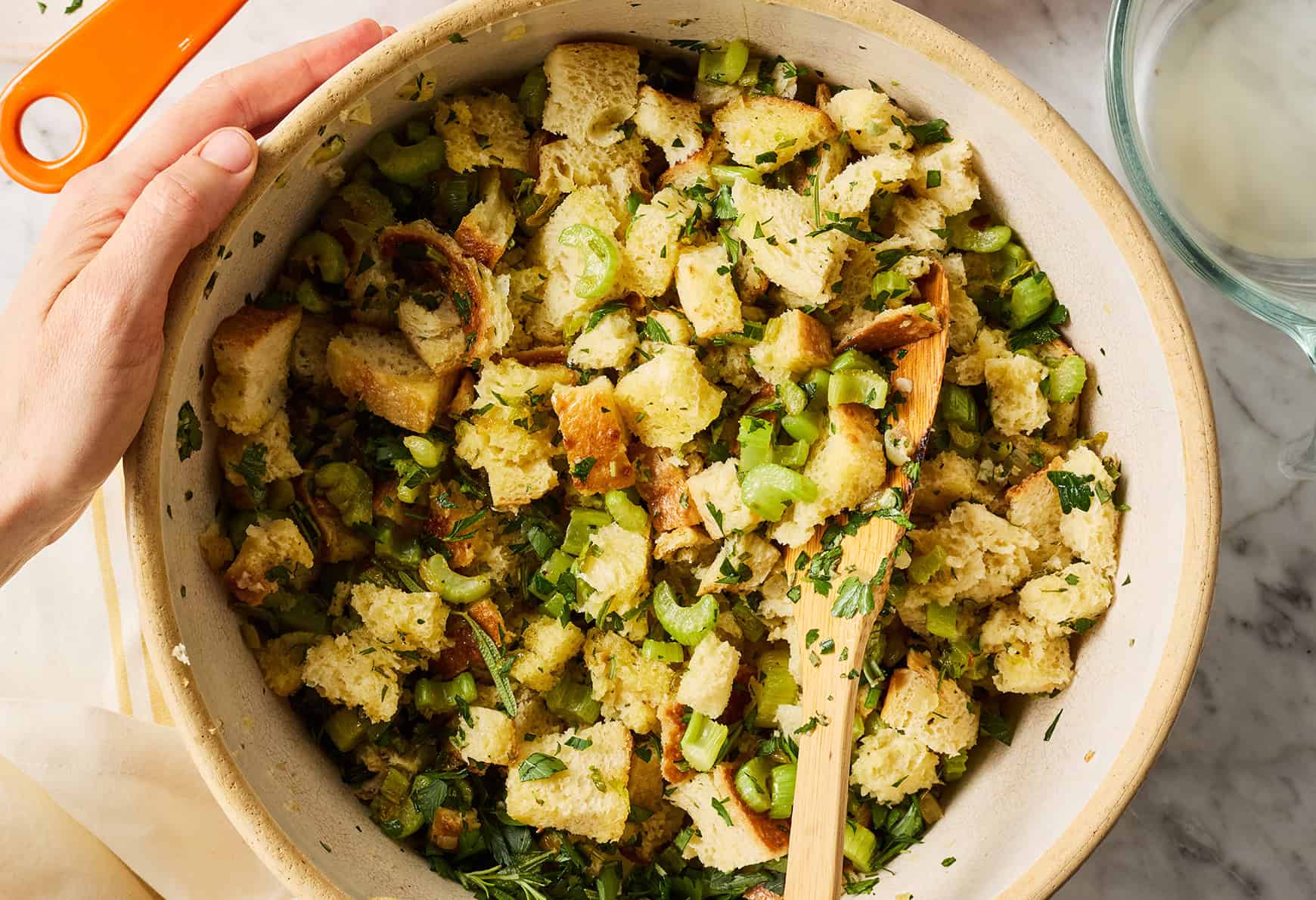Mixing bread cubes with onions, celery, and herbs
