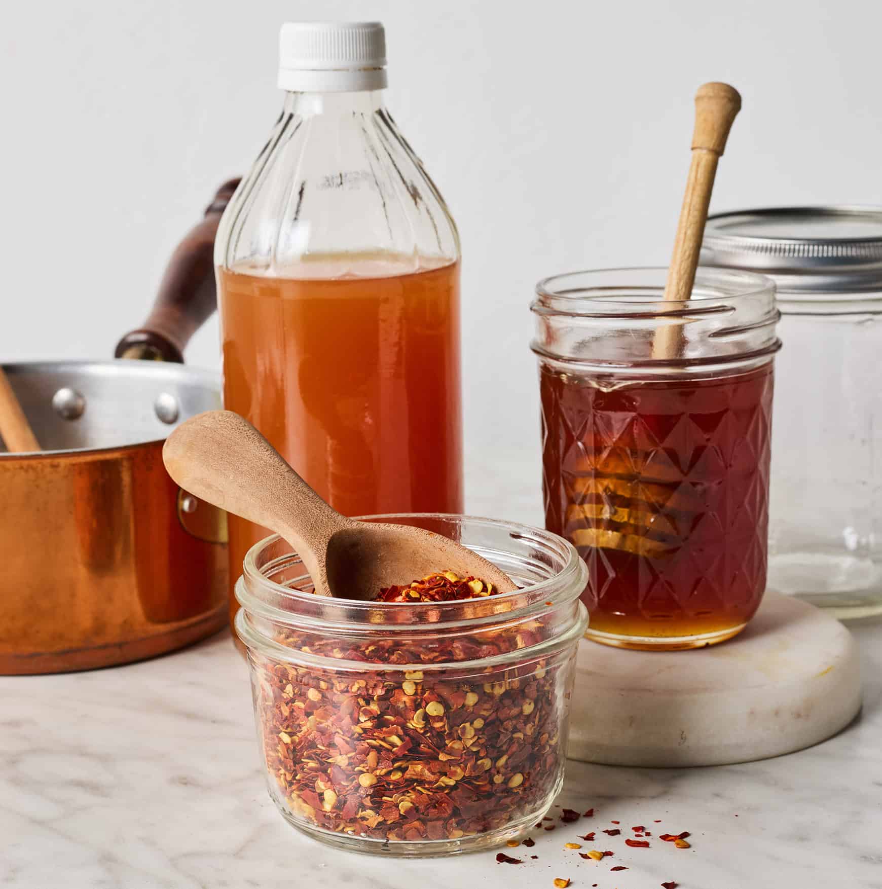 Honey, red pepper flakes, and apple cider vinegar on countertop