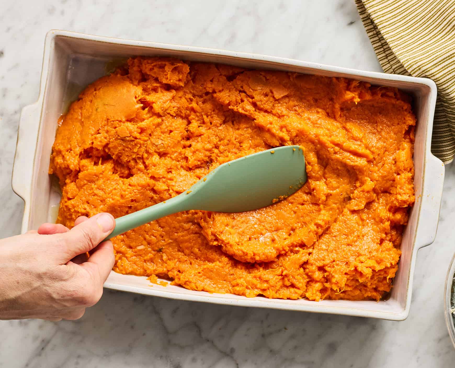 Spreading sweet potato mash in baking dish